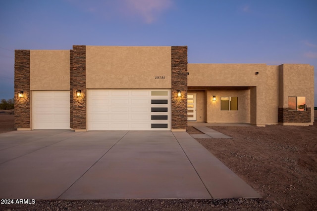 29785 N 203rd Dr, Wittmann, AZ 85361 - pueblo revival-style home featuring concrete driveway, stucco siding, stone siding, and an attached garage