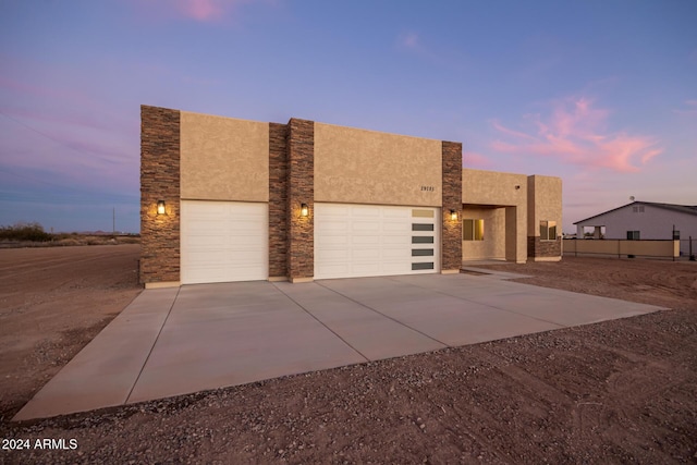 29785 N 203rd Dr, Wittmann, AZ 85361 - view of front of home featuring a garage, concrete driveway, stucco siding, and stone siding