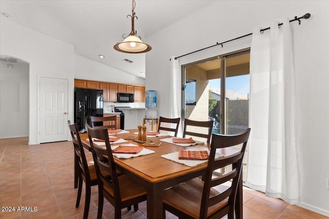 tiled dining space featuring vaulted ceiling