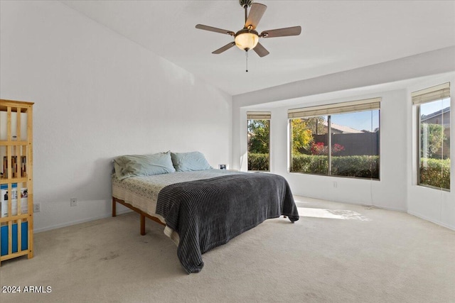 bedroom featuring light carpet, vaulted ceiling, and ceiling fan