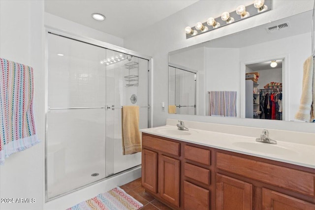 bathroom with tile patterned flooring, vanity, and an enclosed shower