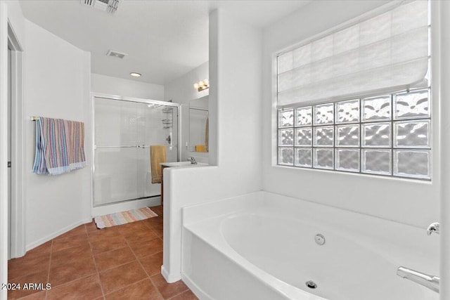 bathroom with tile patterned floors, a wealth of natural light, sink, and plus walk in shower