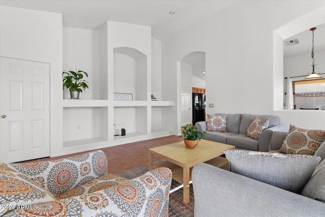 living room with tile patterned flooring, built in shelves, and vaulted ceiling