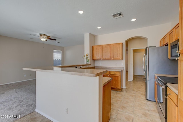 kitchen with sink, ceiling fan, kitchen peninsula, light carpet, and electric stove