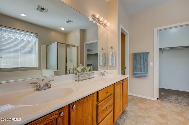 bathroom featuring vanity, a shower with shower door, and tile patterned floors