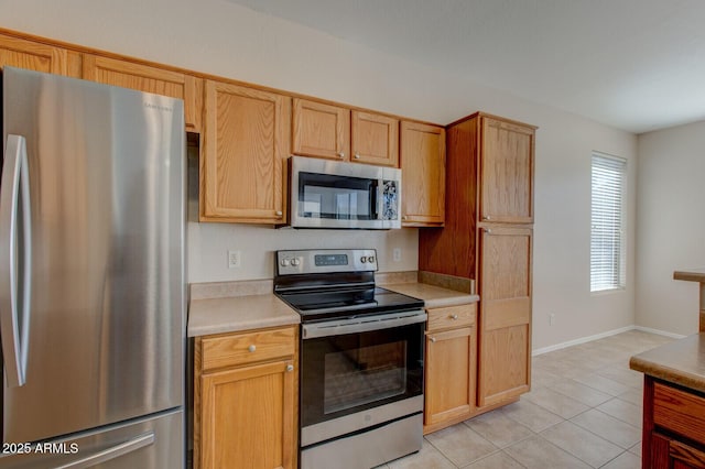 kitchen featuring light tile patterned flooring and appliances with stainless steel finishes