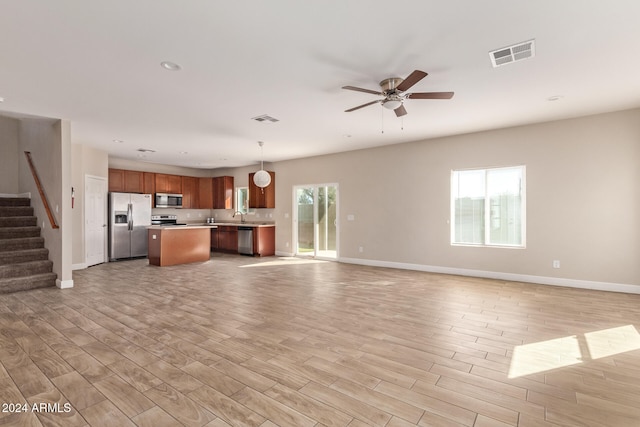 unfurnished living room with light hardwood / wood-style flooring and ceiling fan