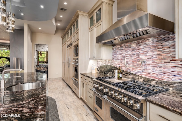 2001 N 1st Ave, Phoenix, AZ 85003 - kitchen with dark stone counters, appliances with stainless steel finishes, wall chimney exhaust hood, tasteful backsplash, and light wood-type flooring
