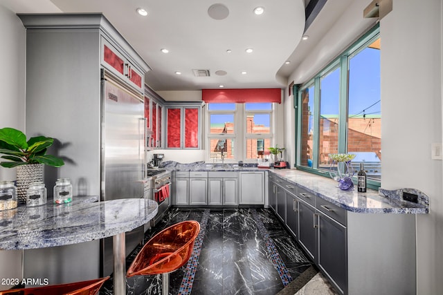 2001 N 1st Ave, Phoenix, AZ 85003 - kitchen with premium appliances, light stone countertops, kitchen peninsula, gray cabinetry, and dark tile floors