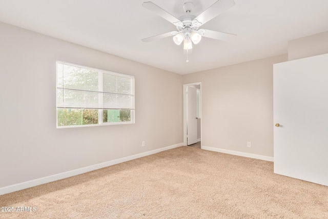 spare room with ceiling fan and light carpet