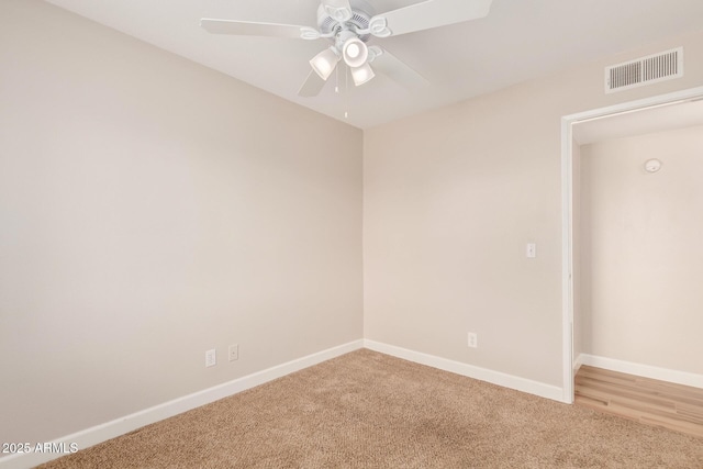 carpeted spare room featuring ceiling fan