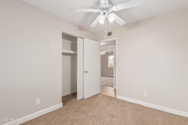 unfurnished bedroom featuring light carpet, ceiling fan, and a closet