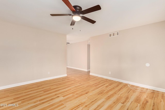 empty room with ceiling fan and light hardwood / wood-style flooring