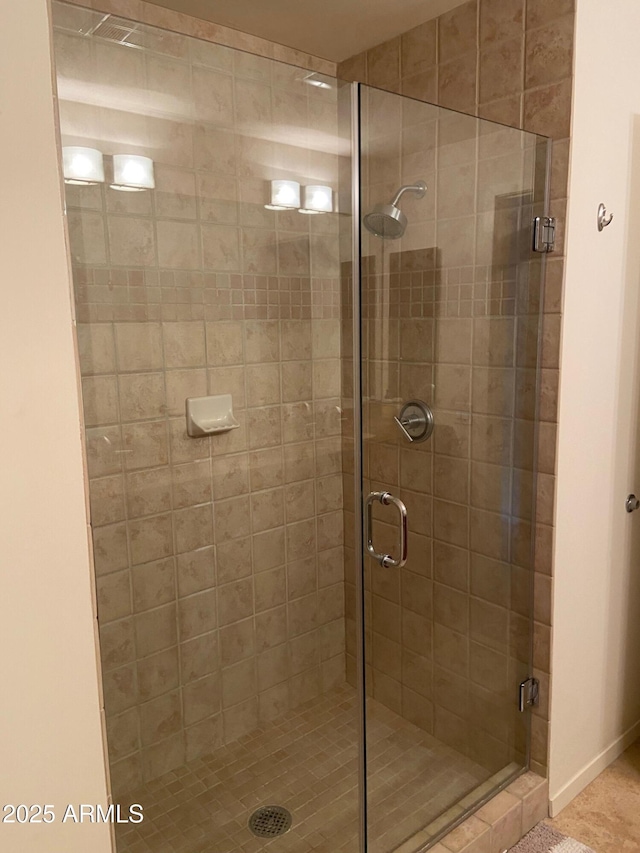bathroom with baseboards and a stall shower