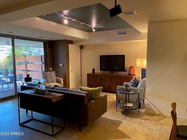 living room featuring visible vents, rail lighting, baseboards, and expansive windows