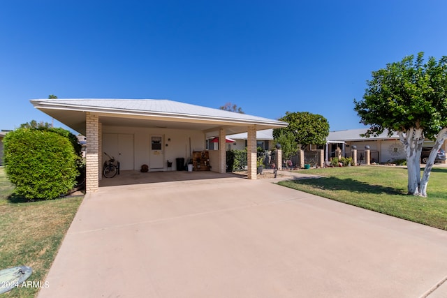 view of front of property featuring a front yard and a carport