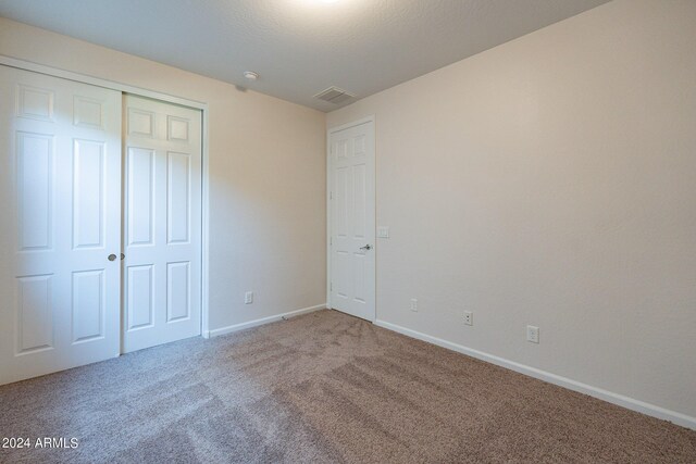 unfurnished bedroom with a closet and carpet floors