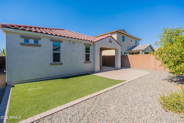 rear view of property featuring a patio and a lawn