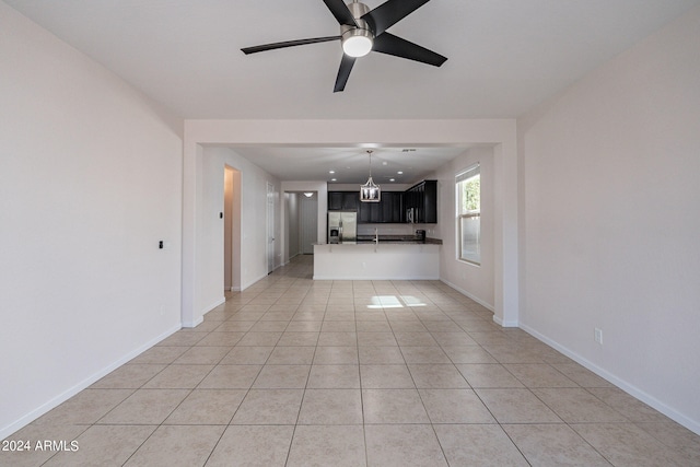 unfurnished living room featuring ceiling fan, sink, and light tile patterned flooring