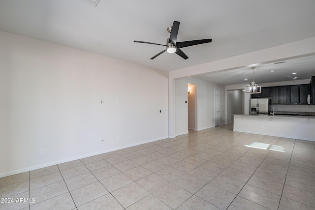 unfurnished living room featuring ceiling fan, light tile patterned floors, visible vents, and baseboards