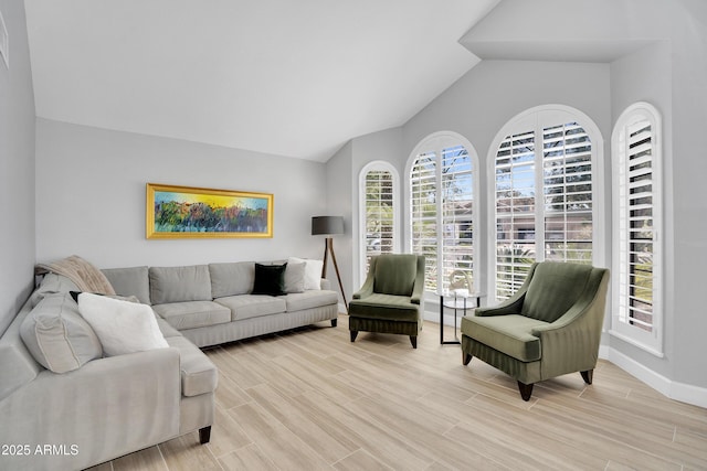 living room with wood tiled floor, baseboards, and vaulted ceiling