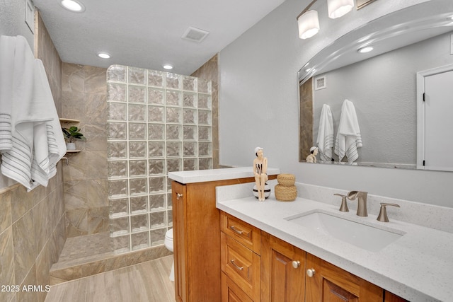 full bathroom with vanity, recessed lighting, toilet, a walk in shower, and visible vents
