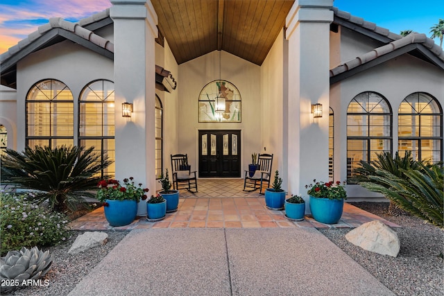 property entrance featuring french doors, stucco siding, and a tile roof