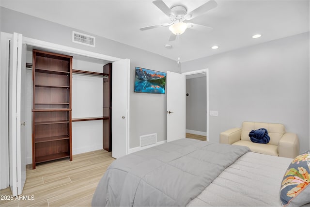 bedroom featuring light wood finished floors, visible vents, a closet, and baseboards