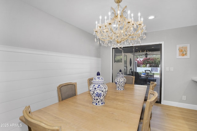 dining space featuring a chandelier, wood finished floors, and baseboards