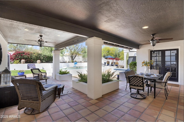 view of patio / terrace with a ceiling fan, a fenced backyard, outdoor dining space, french doors, and a fenced in pool