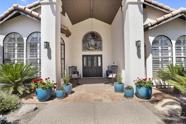 doorway to property featuring french doors, stucco siding, and a tiled roof