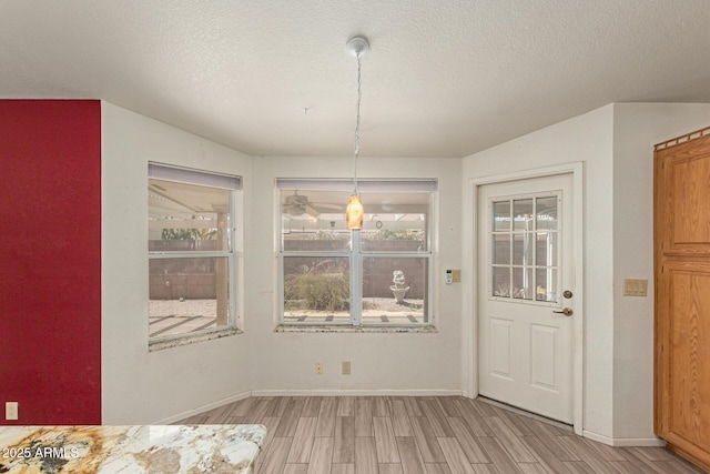 7839 E Milagro Ave, Mesa, AZ 85209 - unfurnished dining area with light wood finished floors and a textured ceiling
