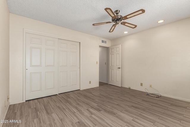 7839 E Milagro Ave, Mesa, AZ 85209 - unfurnished bedroom with light wood finished floors, recessed lighting, a textured ceiling, a closet, and ceiling fan