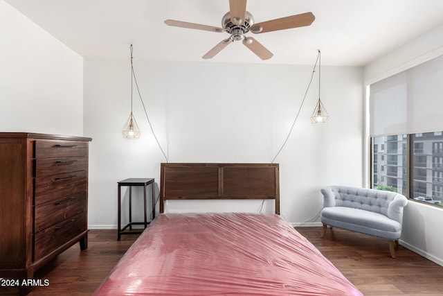 bedroom with dark hardwood / wood-style flooring and ceiling fan