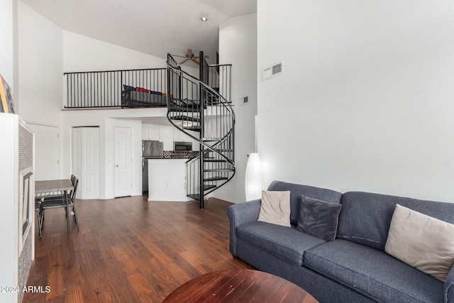 living room featuring high vaulted ceiling and dark hardwood / wood-style floors