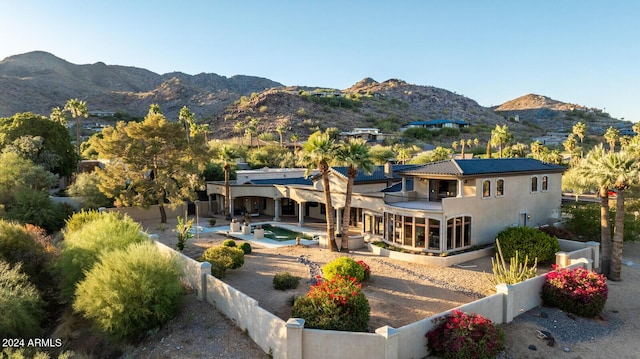 rear view of property with a mountain view, a patio area, a balcony, and a fenced in pool