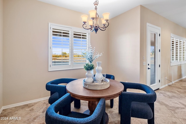 tiled dining room featuring a chandelier