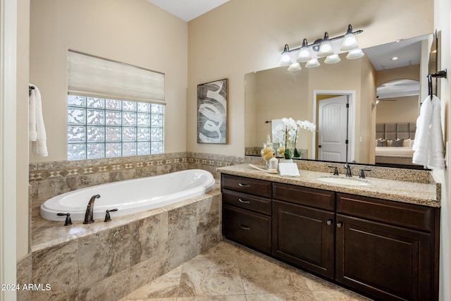 bathroom featuring vanity, tile patterned flooring, ceiling fan, and tiled tub