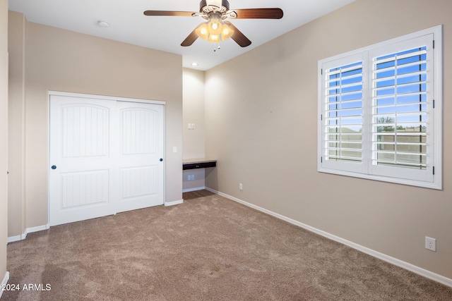 unfurnished bedroom featuring light carpet, ceiling fan, and a closet