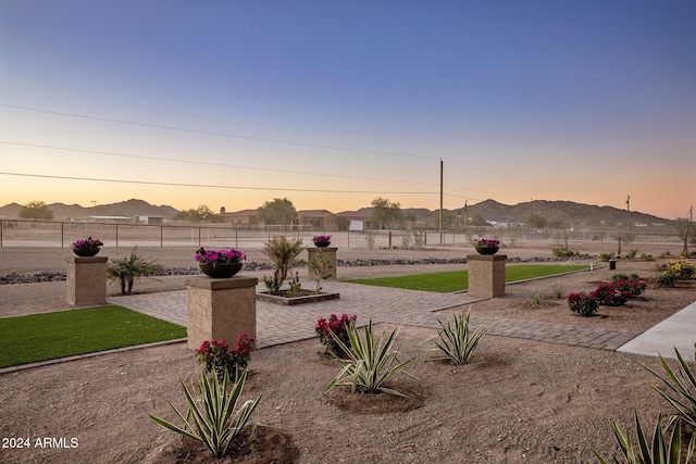 yard at dusk featuring a mountain view and a patio