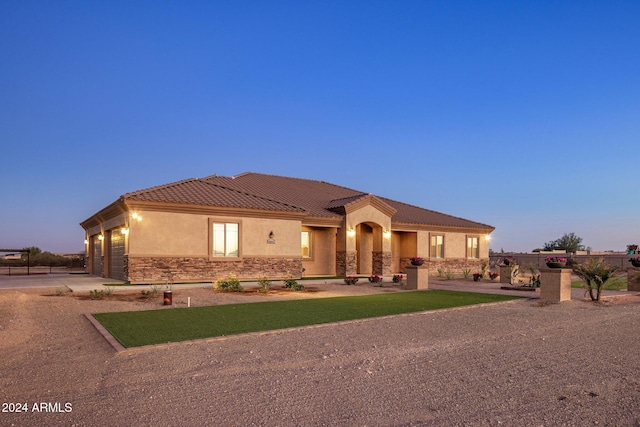 mediterranean / spanish-style home featuring a lawn and a garage