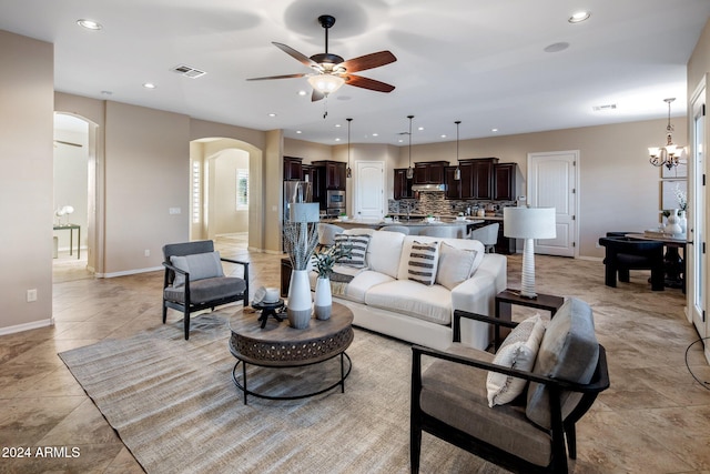 living room featuring ceiling fan with notable chandelier