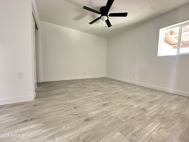 empty room with ceiling fan and light hardwood / wood-style flooring