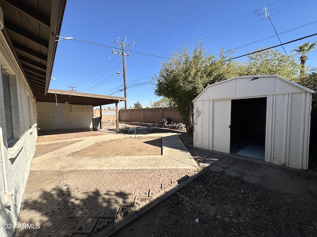 view of yard with a storage shed and a patio