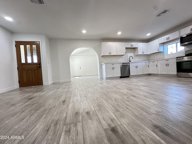 kitchen featuring sink, white cabinetry, stainless steel appliances, and light wood-type flooring