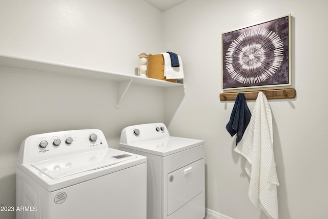 laundry area with washing machine and dryer and baseboards