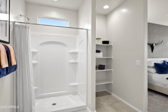 bathroom with a shower stall and baseboards