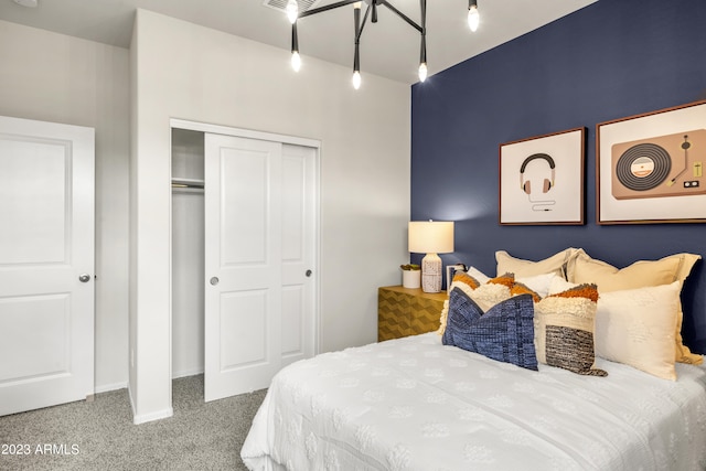 carpeted bedroom with a closet, track lighting, and baseboards
