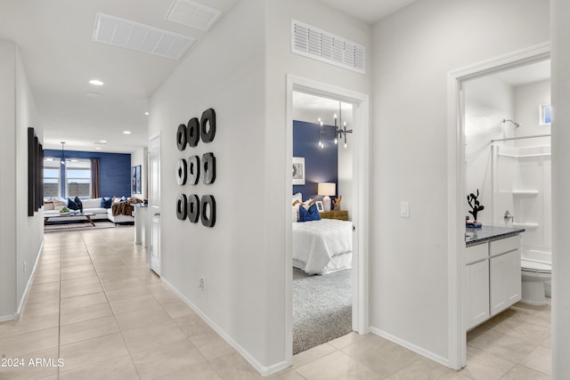 hall with light tile patterned floors, recessed lighting, and baseboards