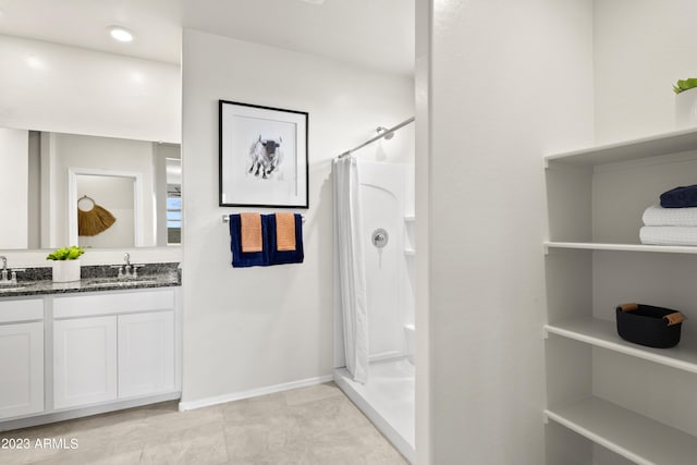 full bath featuring a shower with curtain, double vanity, baseboards, and tile patterned flooring